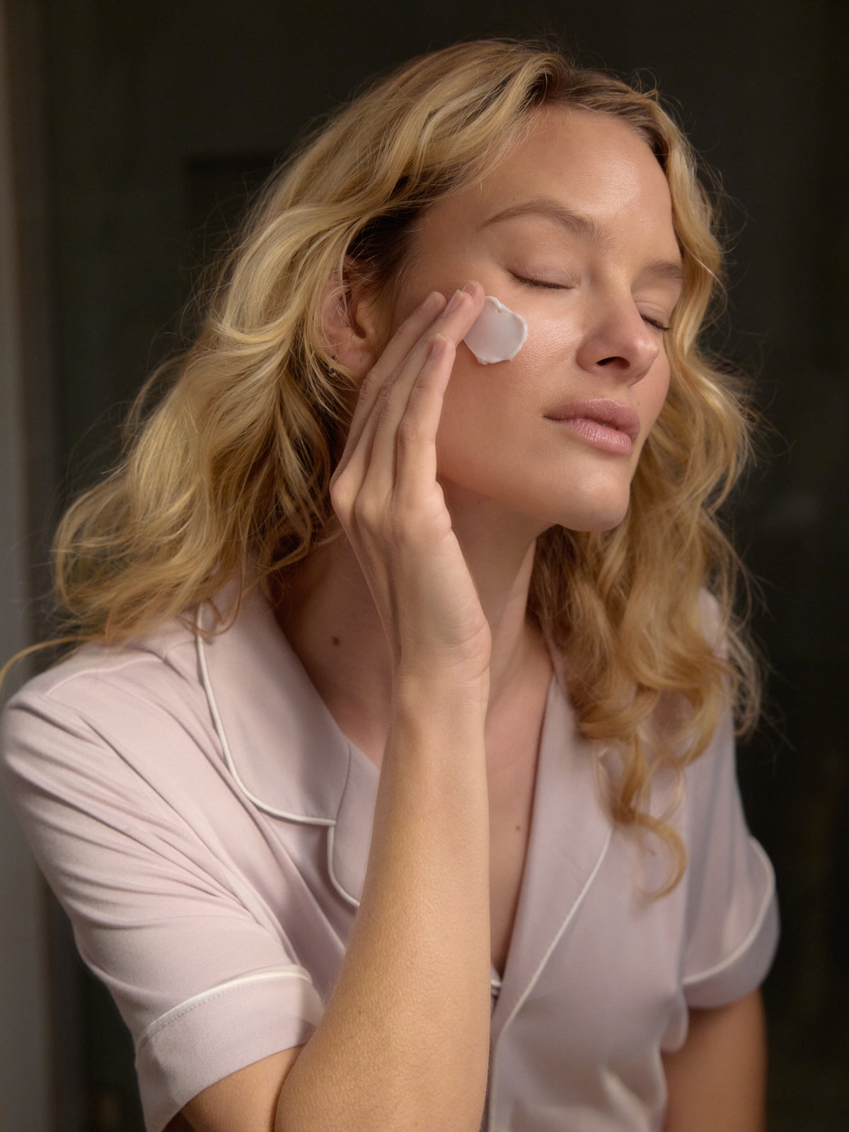 A woman applies some Fount Society Night Cream to her face. |Size:Mini