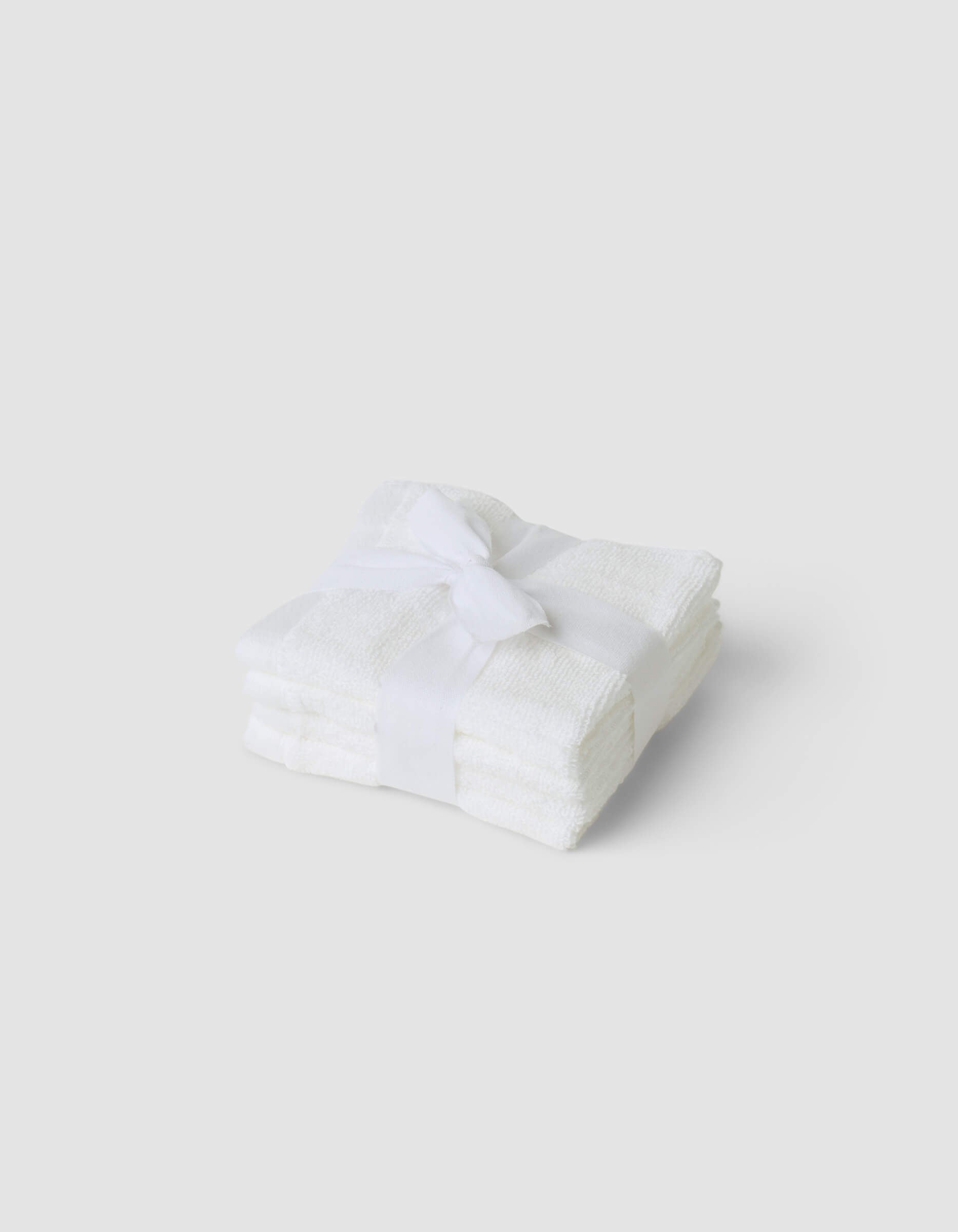 A stack of 4 white washcloths tied with a white ribbon|Color:White
